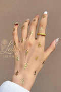 Hand with gold henna designs on a brown background, featuring the Lesley Henna logo.