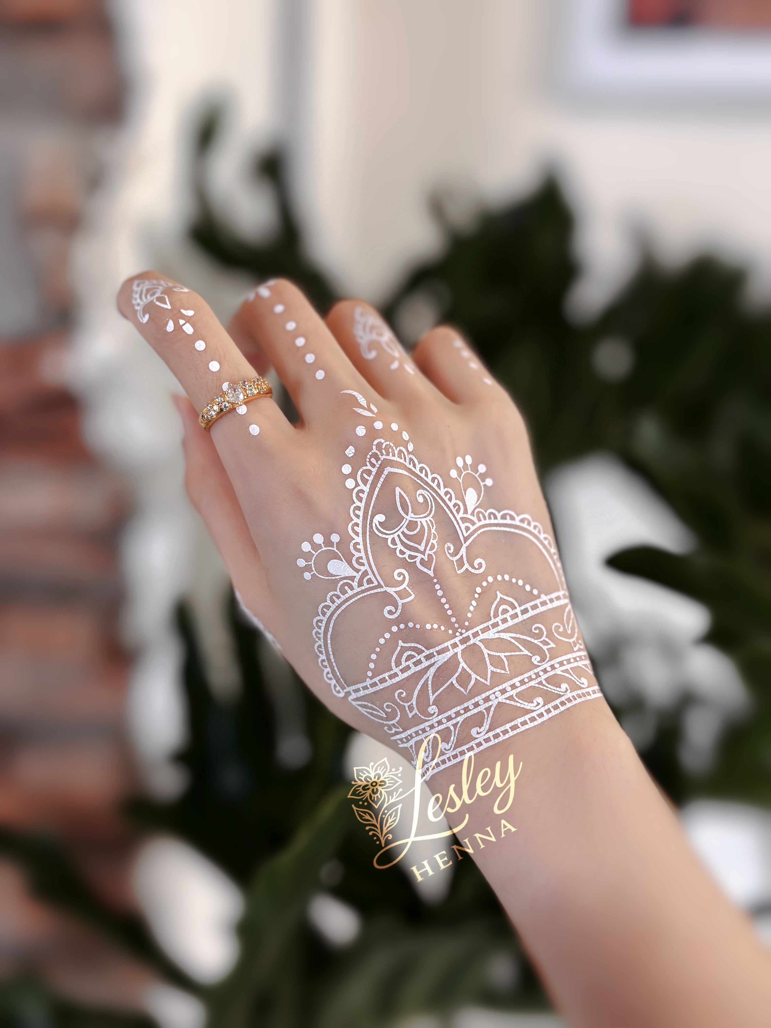 Hand with white henna design, henna for wedding event 